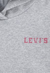 Felpa grigia con cappuccio realizzata in tessuto morbido e testurizzato. Presenta un logo "LEVI'S" rosa ben visibile sul petto. Include un cappuccio con cordoncino.
