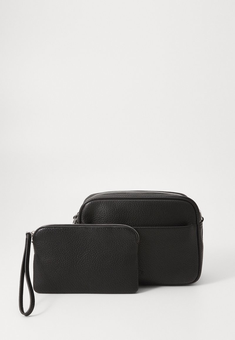 Due borse in pelle nera: una borsa rettangolare più grande con cerniera e una pochette più piccola con un cinturino da polso, entrambe con una finitura testurizzata.