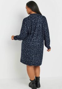 Robe bleu foncé à manches longues avec un motif léopard, fabriquée en tissu doux, dotée d'une coupe décontractée et d'un col rond.