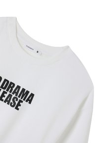 Felpa bianca con colletto a girocollo, caratterizzata da un audace testo nero che recita "DRAMA PLEASE." Realizzata in morbido cotone. L'etichetta della taglia indica "S."
