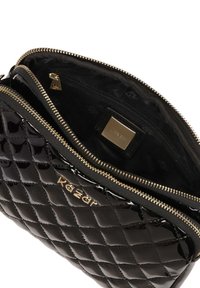 Borsa in pelle verniciata nera con design trapuntato, zip dorata e tasca interna. Presenta una placca con logo all'interno del compartimento principale.