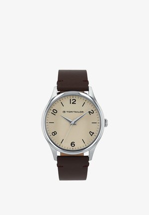 Analog Tom Tailor wristwatch with beige dial, black numerals, silver case, and dark brown leather strap showing 10:10:36.