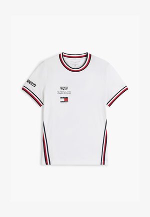 T-shirt bianca a maniche corte con colletto e polsini a righe rosse, nere e bianche, loghi Cadillac Formula 1 e Tommy Hilfiger sul davanti.