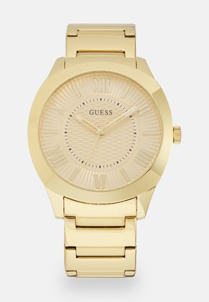 Goldfarbene Guess-Armbanduhr mit römischen Ziffern, strukturiertem Zifferblatt und verbundenem Metallarmband.