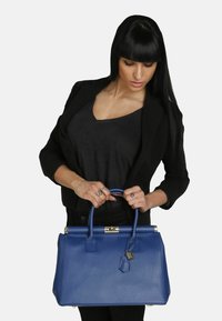 Bolso de piel azul con forma estructurada, acentos de hardware dorado y asas superiores dobles. Acabado texturizado para un detalle adicional.