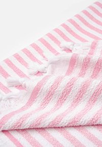 Asciugamano in cotone a righe rosa e bianco, con trama testurizzata e bordi frangiati, che presenta sezioni alternate in tinta unita e in spugna.