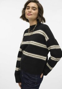 Maglione nero lavorato a maglia con strisce orizzontali crema, colletto a costine e maniche ampie. Tessuto morbido, abbinato a jeans scuri.