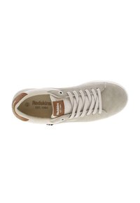 Sneakers in suede beige con lacci bianchi, un dettaglio in pelle marrone sul tallone e una suola in gomma, con il marchio "Redskins" sulla linguetta.