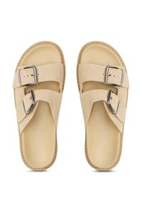Sandales en suedine beige avec deux larges brides et boucles en métal argenté. Semelle texturée avec une finition naturelle. Design ouvert à l'avant.
