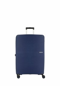 Valigia rigida navy con motivi diagonali testurizzati, manico retraibile e quattro ruote per la mobilità. Presenta il logo nell'angolo in basso.
