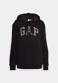 Sweat à capuche noir avec poche avant et capuche, avec un grand logo G.A.P. argenté pailleté sur la poitrine et des cordons noirs.