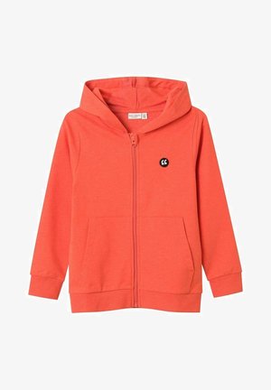 Koraalkleurige hoodie met ritssluiting, gemaakt van zachte stof, met een zak aan de voorkant, een capuchon met trekkoord en een zwart logo-accent op de borst.