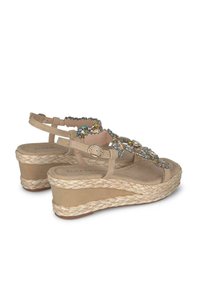 Beige wedge sandalen met gevlochten juten zolen, versierd met kleurrijke edelstenen op de banden, met een verstelbare enkelgesp.