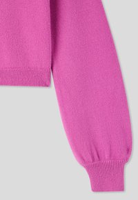 Manica di maglione rosa aderente con una texture morbida, polsini a coste e finiture pulite. Il materiale appare leggero e liscio.