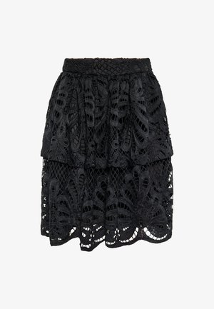 Mustriga musta pitsist seelik, millel on tiered-disain, keerukad lõikused, tekstureeritud kangas ja laineline äär. Elastne vöökoht on kaasas.