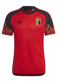 Camiseta de fútbol roja de manga corta con detalles negros, que presenta un escudo de Bélgica y un patrón de llamas en las mangas. Hecha de tejido ligero.