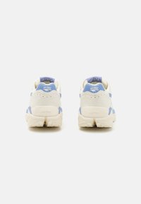 White and light blue sneakers featuring a textured upper, padded collar, and chunky sole with clear branding on the heel and tongue.