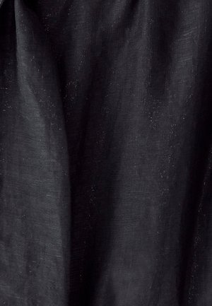 Sort stof med en tekstureret overflade, der har en subtil glans og lette variationer i farve og lysstyrke, hvilket skaber et lagdelt udseende.