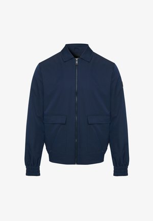 Chaqueta azul marino con cierre frontal, cuello extendido, dos bolsillos frontales y puños elásticos para un ajuste seguro. Textura de tela suave.