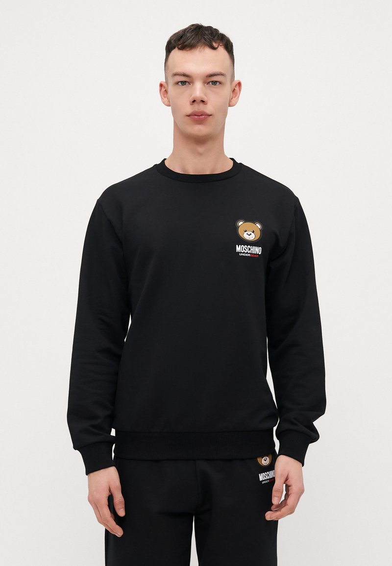 Black crewneck sweatshirt made from soft fabric, featuring a bear graphic and logo in contrasting colors on the chest and hem.