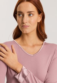 Paita pitkähiha, vaaleanpunainen, v-pääntieteellä, jossa on sileä rakenne ja satiinimaiset hihansuut.