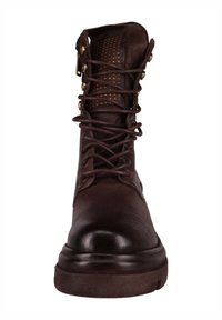 Brązowy skórzany trzewik na sznurowadła z okrągłym noskiem, teksturowaną cholewką, mosiężnymi elementami ozdobnymi oraz perforowanymi detalami na kołnierzu.