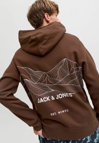 Haut à capuche marron avec un graphique blanc de ligne de montagne au dos, texte de la marque "JACK & JONES" et "EST. MCMXC" au bas.