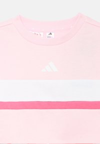 Sudadera rosa con cuello redondo, con rayas horizontales en blanco y rosa más oscuro, y un pequeño logo blanco en el pecho.