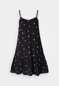 Musta mekko, jossa on säädettävät ohuet olkaimet, löysä istuvuus ja kerroksellinen röyhelöhelma. Koristeltu valkoisilla timantinmuotoisilla kuvioilla.