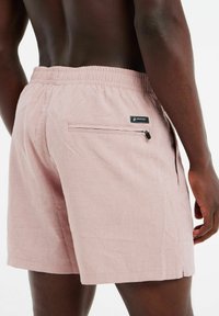 Rosafarbene Badeshorts aus leichtem Material. Mit einem elastischen Bund, einer Reißverschluss-Tasche auf der Rückseite und einem Logopatch an der Seite.