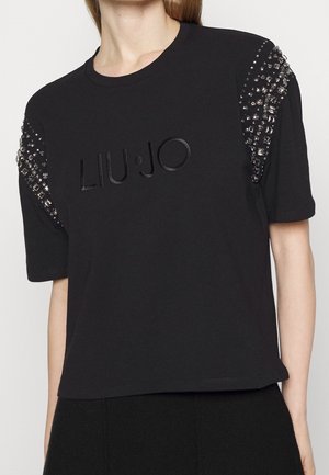 T-shirt nera in cotone con maniche corte, dettagli decorati sulle spalle e il logo "LIU·JO" in rilievo sul davanti.