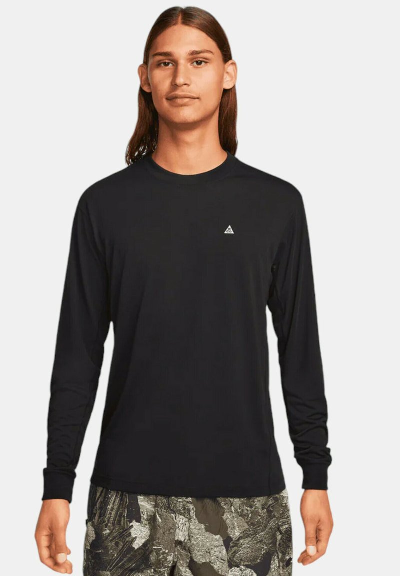 Långärmad svart t-shirt i glatt tyg, med en liten triangulär logotyp på bröstet och rundad halsringning.