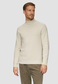 Cremfarbener Rollkragenpullover aus Strickstoff, mit gerippten Bündchen und Saum. Einfaches, klares Design mit subtiler Textur und figurbetonter Silhouette.