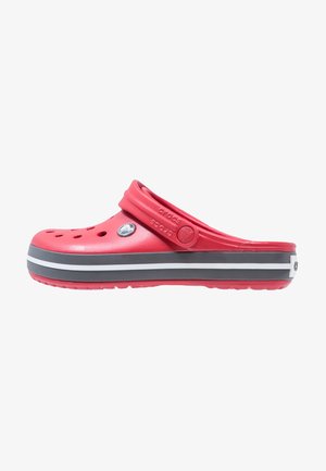 Sabots rouges à bout fermé et talon ouvert, fabriqués en matériau léger, avec des trous de ventilation et une semelle rayée gris et blanc.