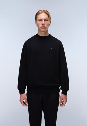Black sweatshirt with a round neckline, ribbed cuffs, and hem. Features a small logo on the chest, made from a soft, textured fabric.