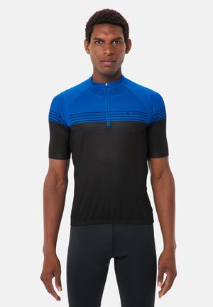 Mann trägt ein kurzärmeliges blau-schwarzes Radsporttrikot mit Reißverschluss vorne, steht mit entspannten Armen vor weißem Hintergrund.