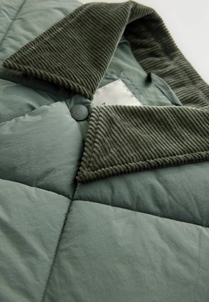 Jachetă puffer matlasată în verde șters cu un guler texturat din catifea, având închidere cu butoane și un material moale, ușor.