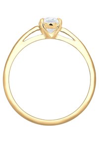 Guldring med en klør-sat klar sten, med en glat skabelon og delte skuldre, der fremhæver et minimalistisk design og poleret overflade.