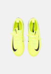 Geel synthetische voetbalschoenen met zwart Nike-logo, gestructureerd design en platte veters. Inclusief hiel-tabben voor gemakkelijke instap.