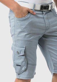 Shorts cargo rayés en bleu clair et blanc. Comprend un design multi-poches, un tissu texturé et une grande poche latérale avec un bouton-pression.