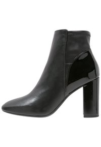 Czarne botki za kostkę wykonane z gładkiej skóry z błyszczącym akcentem z lakierowanej skóry. Posiadają spiczasty dziób oraz masywny, wysoki obcas. Czysty design z przeszyciami.