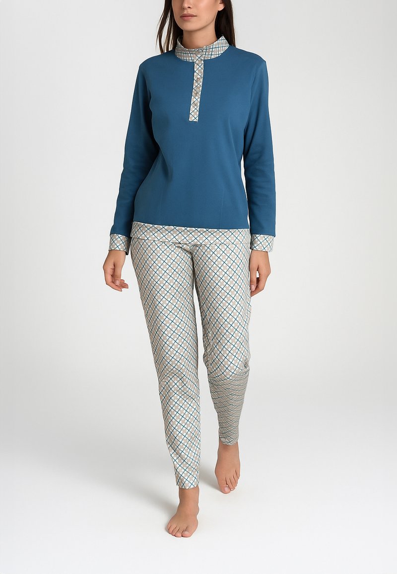 Maglia a maniche lunghe blu melange con colletto decorato, abbinata a pantaloni chiari con motivo a diamante in blu e beige.