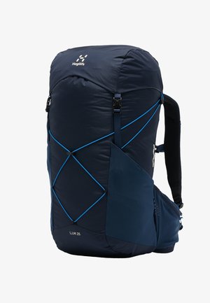 Sac à dos de randonnée Haglöfs L.I.M 25 bleu foncé avec cordons élastiques avant, poche latérale, bretelles rembourrées et ceinture de hanches.