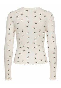 Langærmet top lavet af let ribbet stof, cremefarvet med små pink blomster og grønne bladmotiver, med en flæse forneden og ved ærmerne.