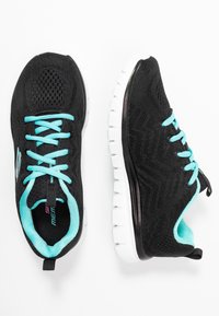 Schwarze Sportschuhe mit einem atmungsaktiven Mesh-Obermaterial, türkisen Schnürsenkeln und einem strukturierten Design, ausgestattet mit einer weißen gepolsterten Sohle und einer Ferse.