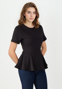 Czarny top z krótkim rękawem, o okrągłym dekolcie i rozkloszowanym hemie. Gładki materiał z dopasowanym korpusem i unikalnymi detalami w postaci fałd. 