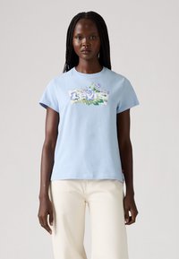 Lys blå bomull t-skjorte med korte ermer, med et blomstrete Levi's-logo designet foran. Glatt tekstur; uformell passform.