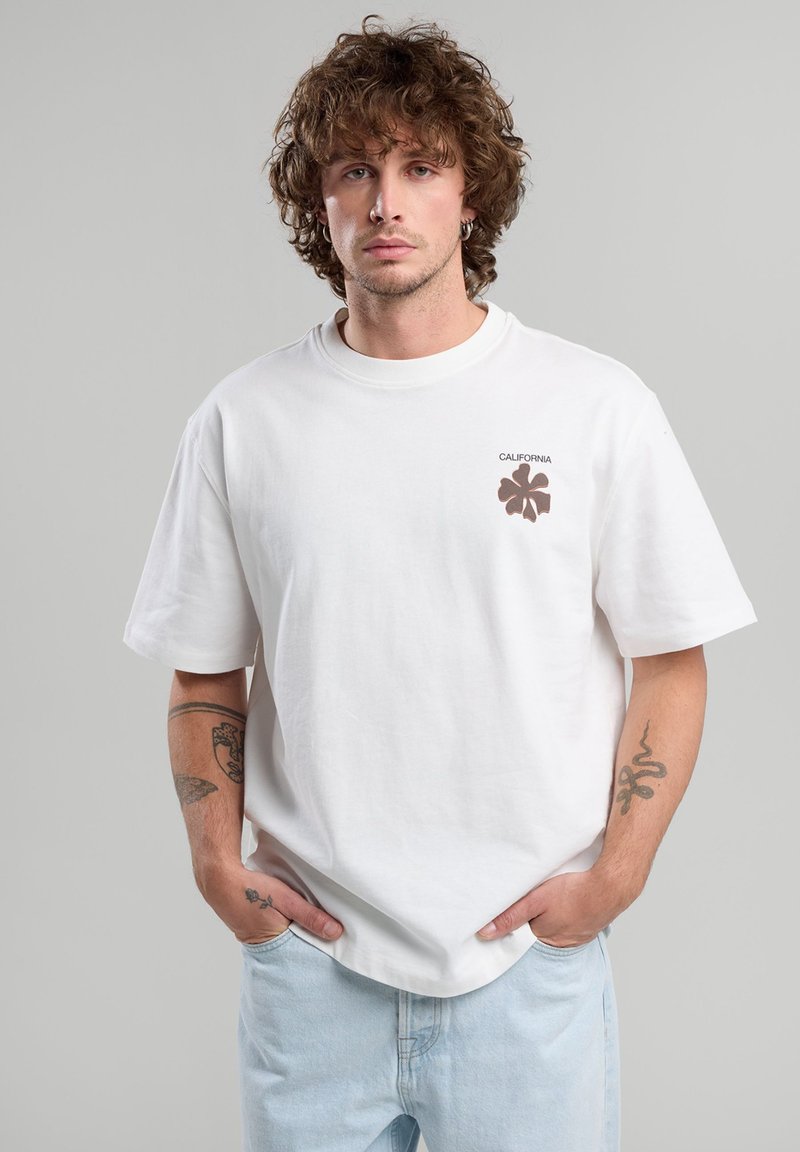 White cotton T-shirt with short sleeves, round neckline, and a small brown floral logo and "CALIFORNIA" text on the left chest.