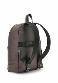 Zaino in tessuto marrone con spallacci neri, dalla forma arrotondata, con cerniere laterali e una maniglia superiore, adatto per uso casual o professionale.