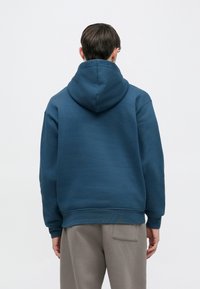 Φούτερ με κουκούλα σε σκούρο μπλε βαμβάκι, με casual γραμμή και ριμπ τελείωμα. Διαθέτει μεγάλη, στρογγυλεμένη κουκούλα και υφασμάτινη υφή.